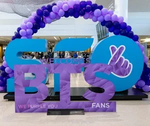 A purple BTS display and ballon arch at SFO